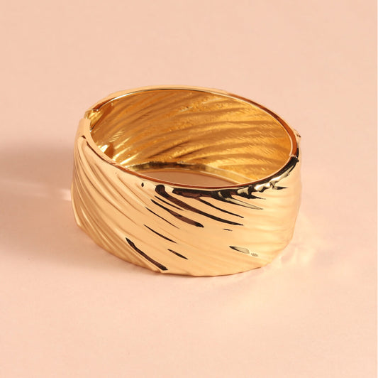 Gold bracelet on a pink background